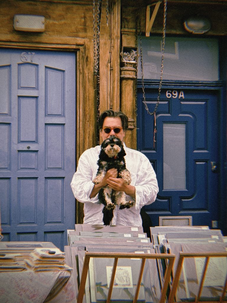 photo of man with sunglasses holding a little dog