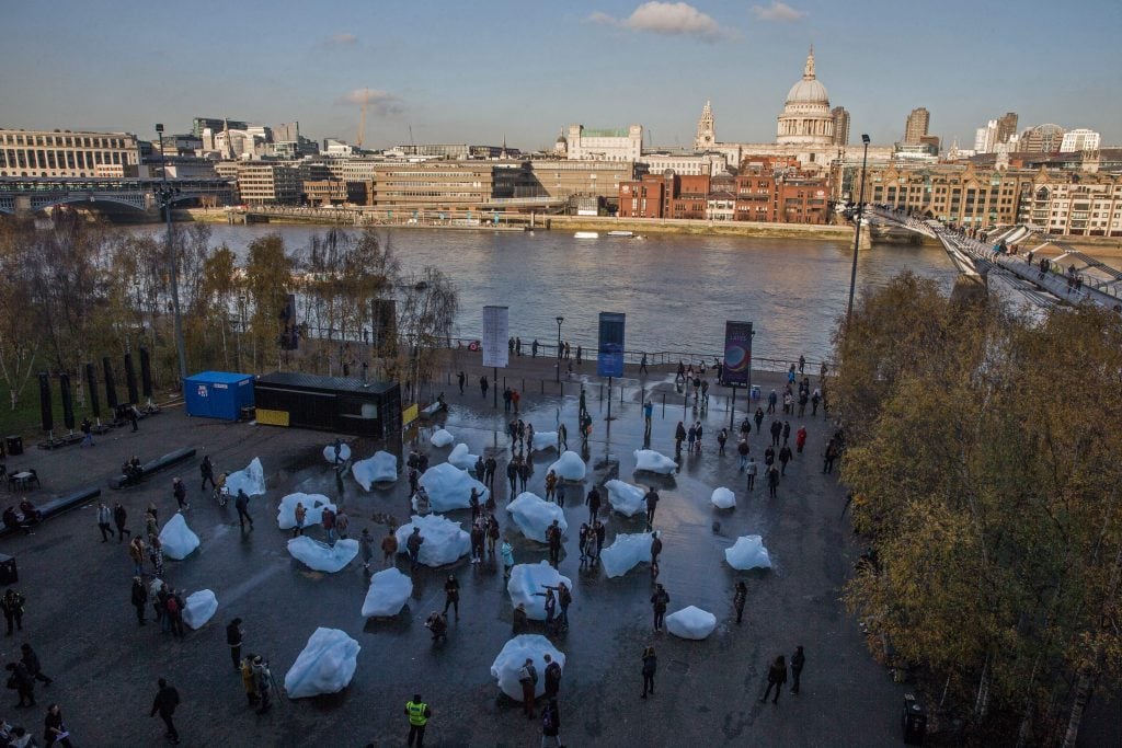 large blocks of ice dot the sidewalk near the thames river in london as part of an art installation 