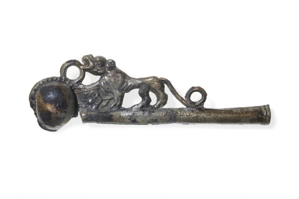 Antique bronze whistle made from pewter, with a lion sitting on top of the pipe