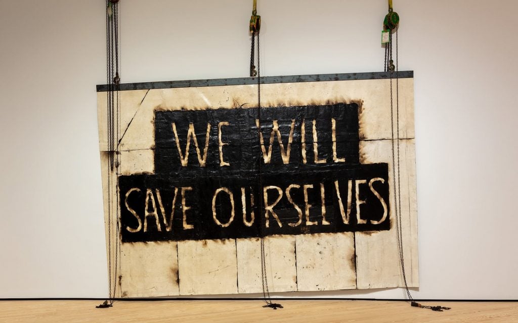 A large artwork that says "W WILL SAVE OURSELVES"