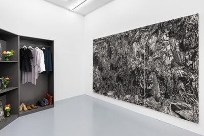 Daniel Arnan Quarshie, Kwatserekwa Mpaboa (2024). Discarded clothes, shoes, and bags, analogue television, discarded glass bottles, synthetic flowers, charcoal drawings on canvas; Into the Badlands (2024). Charcoal on canvas. 240 x 360 cm. Exhibition view: THE ALLEGORY OF DECOY, Galerie Hubert Winter, Vienna (14 September–19 October 2024).