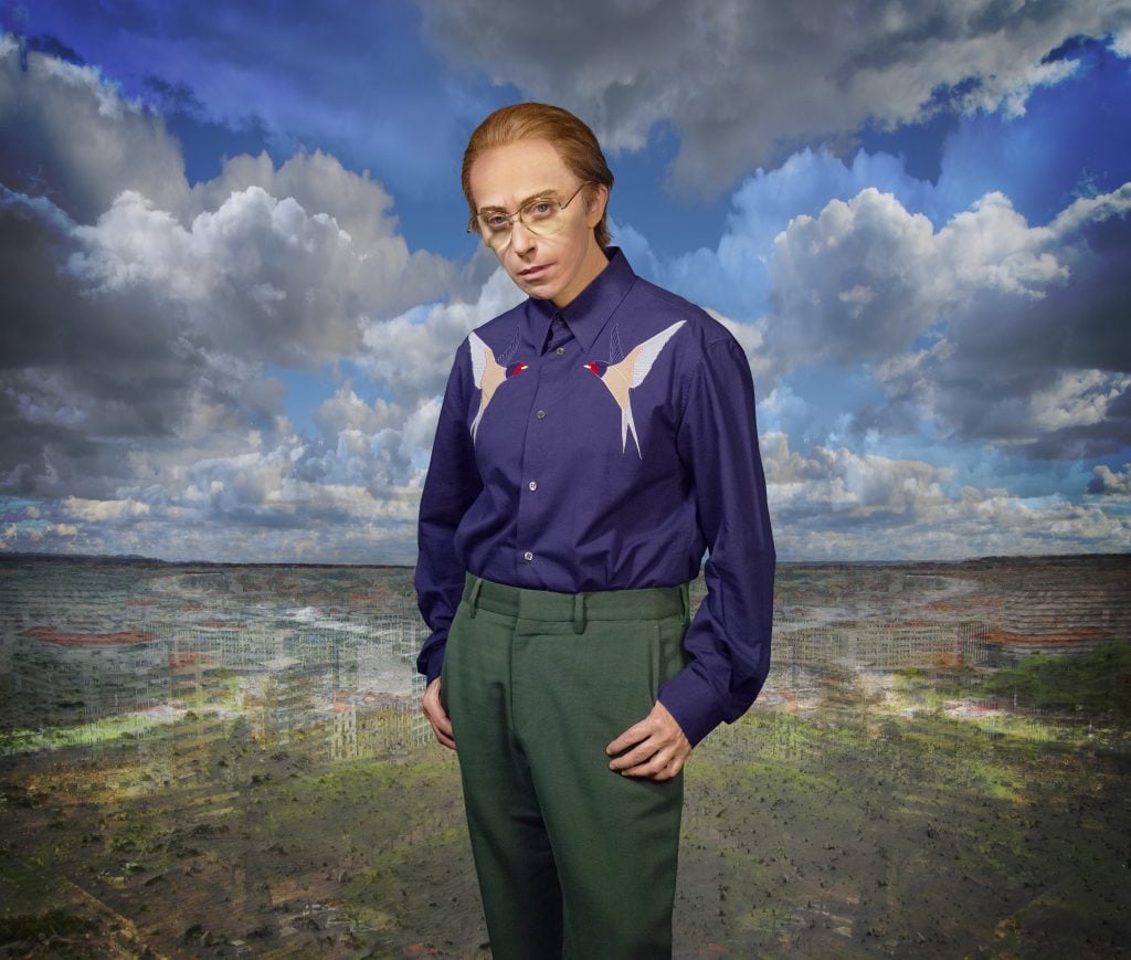 a balding man in a field with clouds