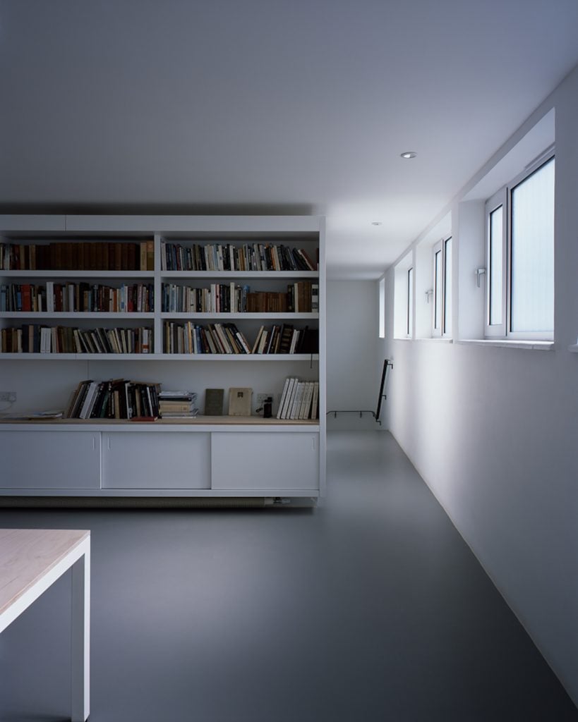 an image of the artist's studio with bookshelves and white walls