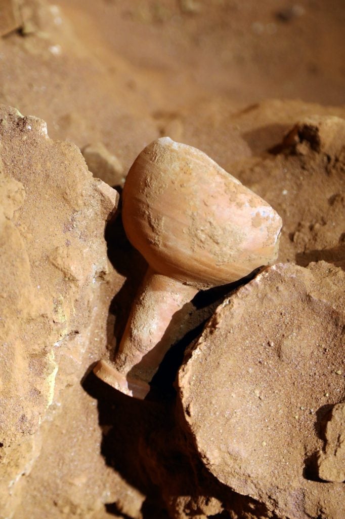 an ancient cup against a rock and sand background