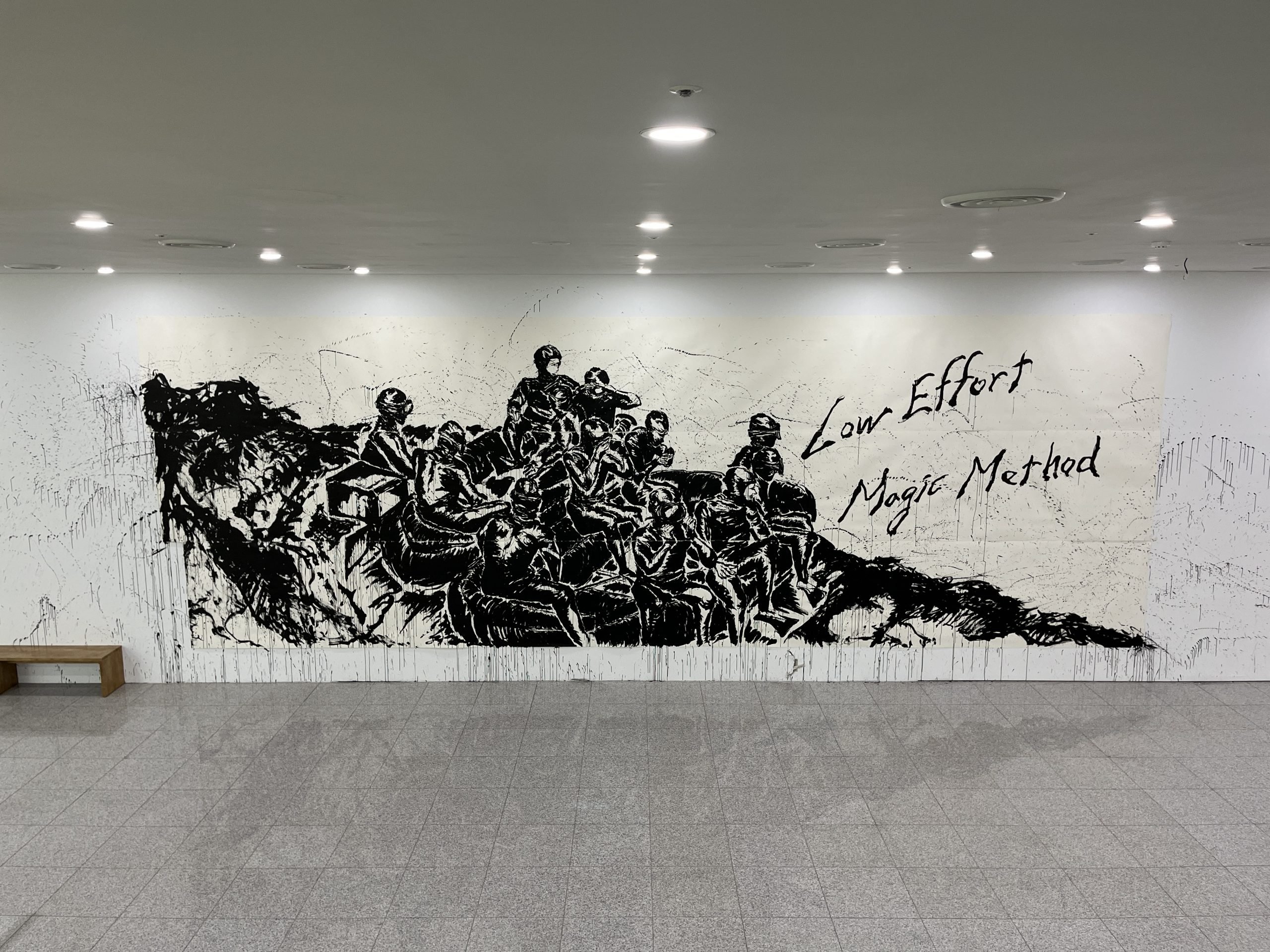 A large ink drawing on paper hangs on a wall. It shows commandos in a boat.