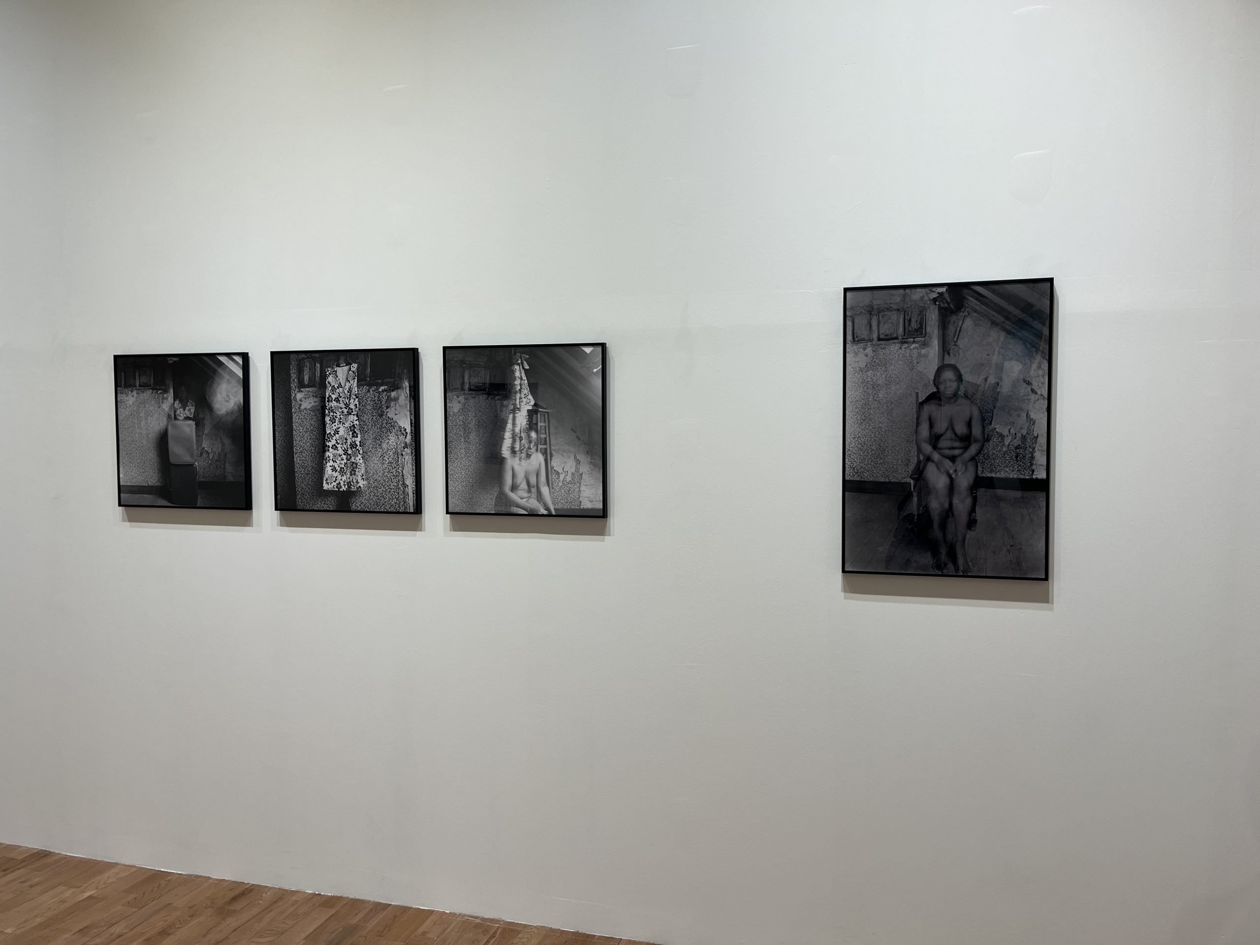 A few black-and-white portraits hang on a wall