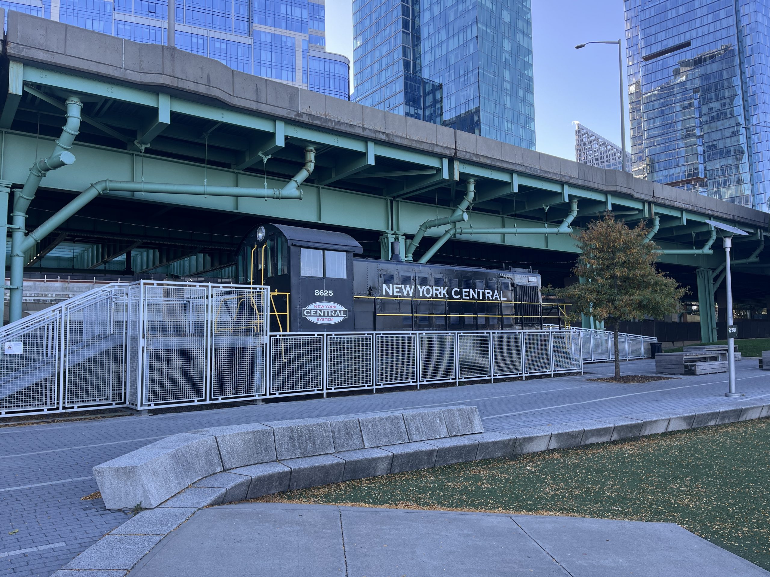 A black locomotive is surrounded by a walkway