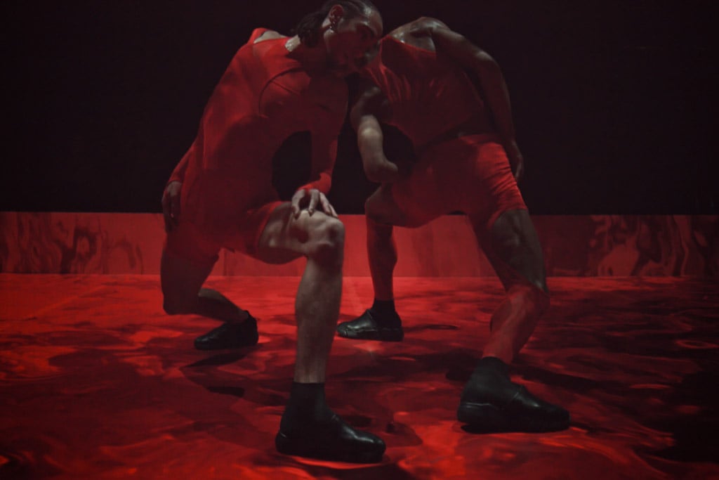 two men dance in a red boxing ring