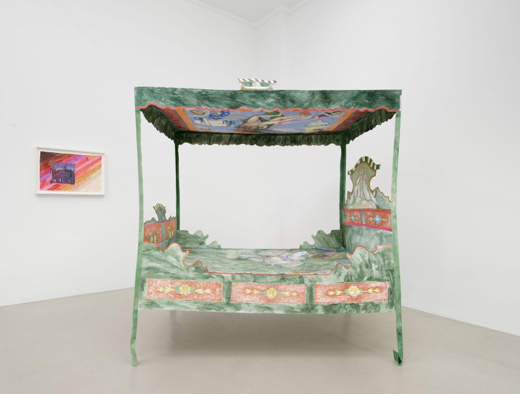 A green and elaborately decorated paper canopy bed by artist Agnes Scherer and a multicolor ink and pen on paper composition on the left wall, both by Agnes Scherer and installed at CherLüdde, Berlin.