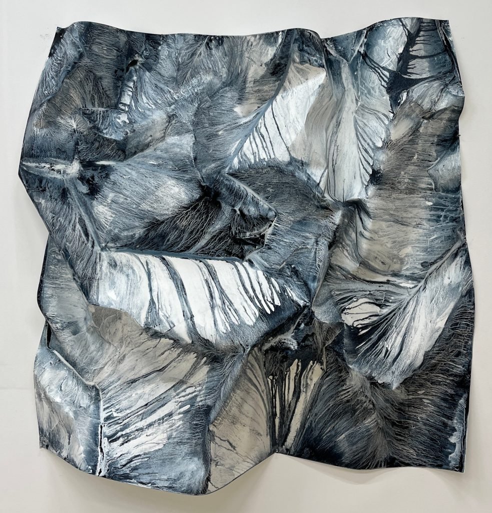 A crumpled abstract watercolor and ink piece by Melissa McGill in dark blues on cream paper.