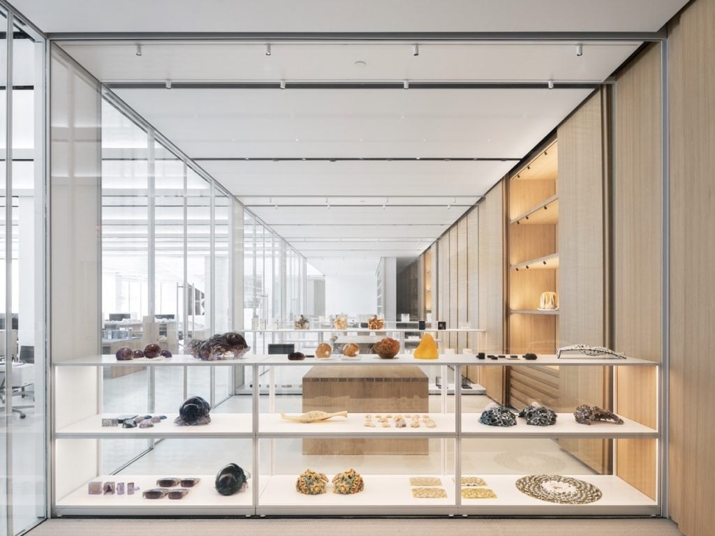 A glass case in a clean, white gallery displaying products