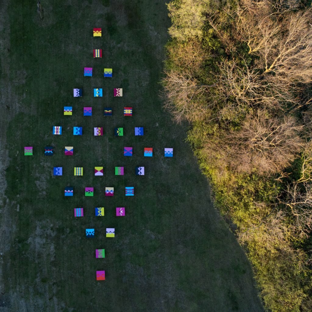 Forty wooden platforms painted and embellished with ribbons and tile are seen in an art installation on Sugarloaf Mound in St. Louis in 2023