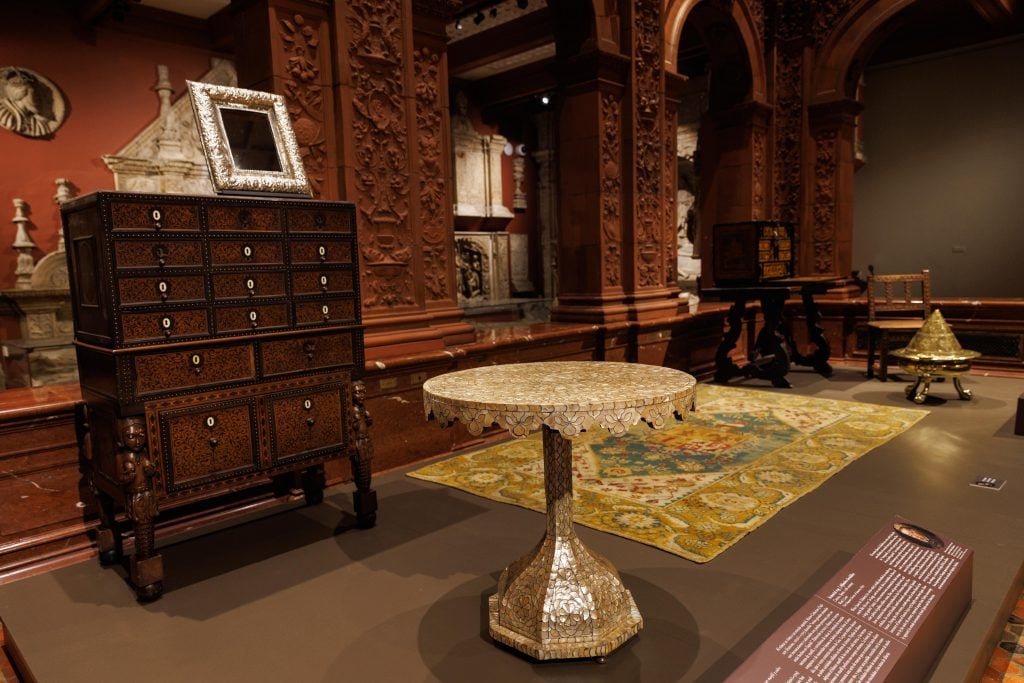 an interior shot of a museum display shows furniture and carpeting and domestic ways to display collections 