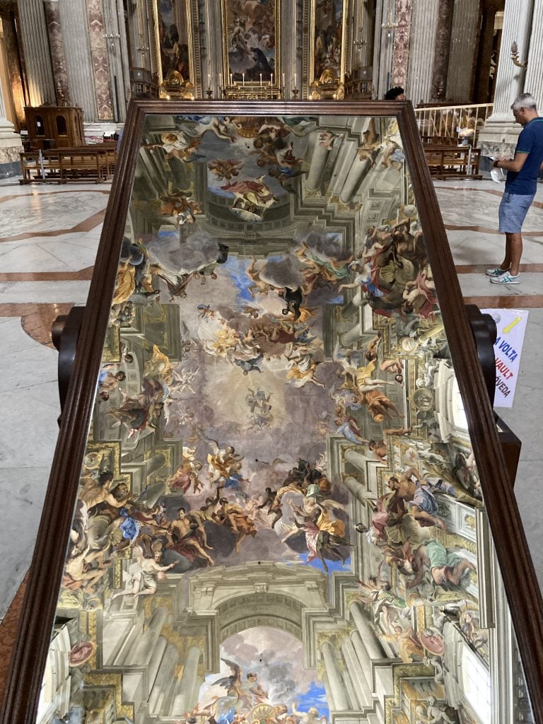 A photograph of a mirror reflecting the ceiling fresco above the TikTok famous Chiesa di Sant'Ignazio di Loyola.