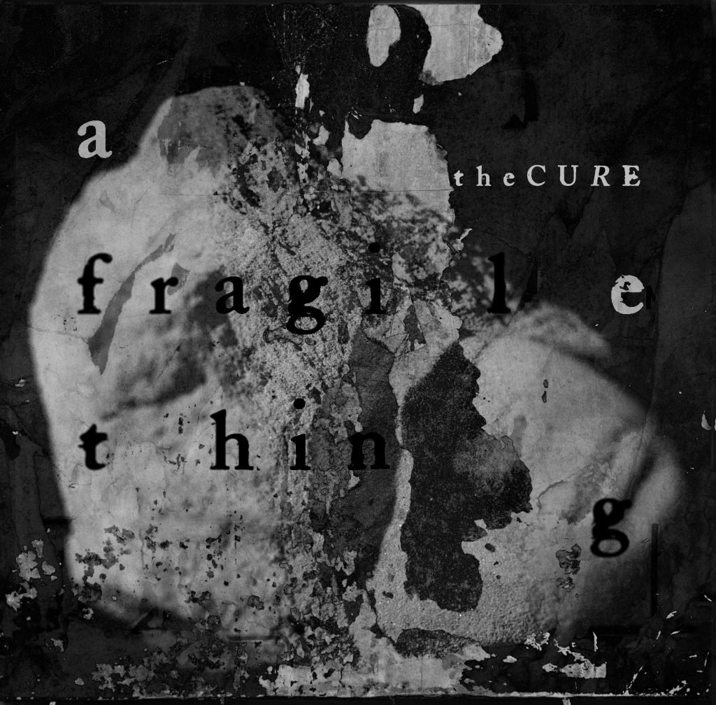 Album cover for the Cure's "A Fragile Thing," featuring a stone sculpture of a head overlaid with various other stone textures