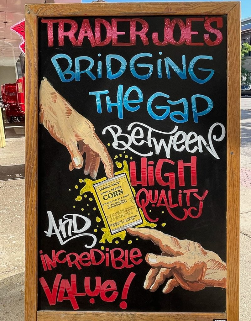 A sign showing two hands reaching out to grasp a corn can, with the slogan "Bridging the Gap"