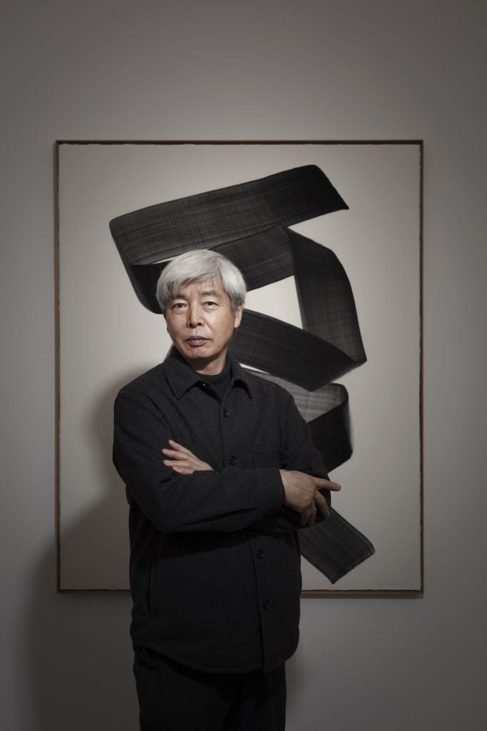 Portrait of Lee Bae in front of a painting