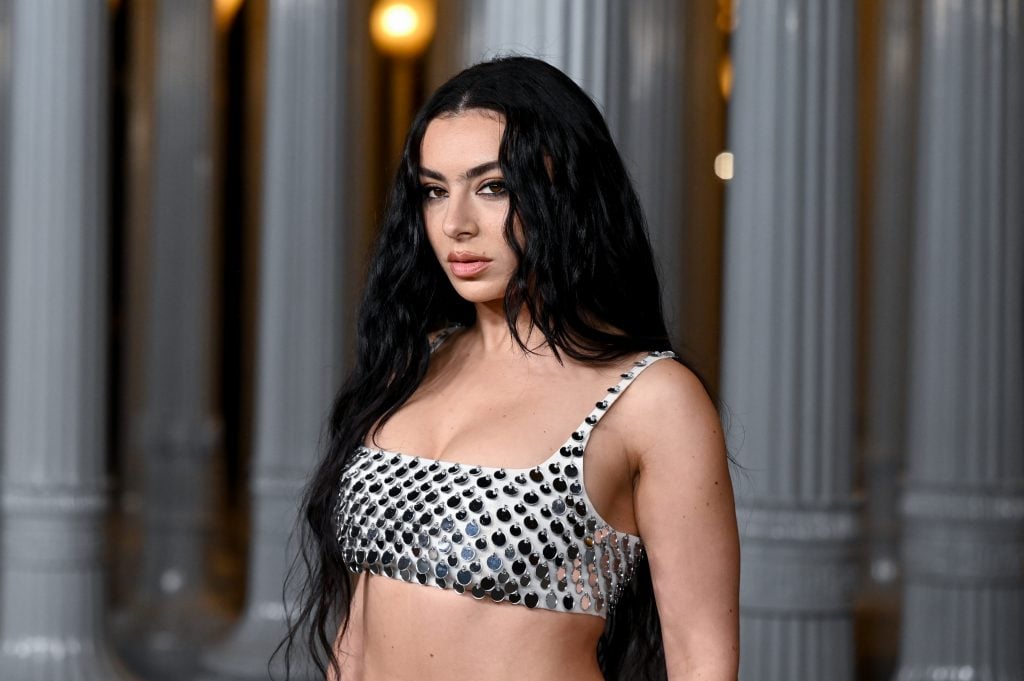 Charlie XCX standing in fancy dress in front of LACMA's outdoor sculpture in LA