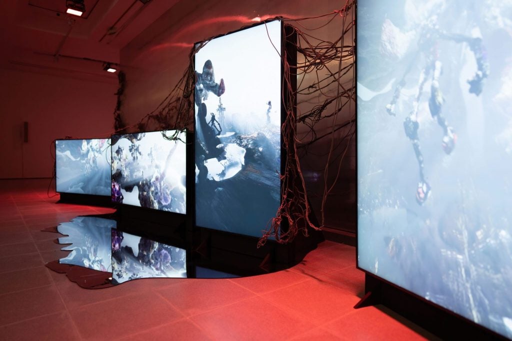 an installation featuring digital screen with black and white images and a red background