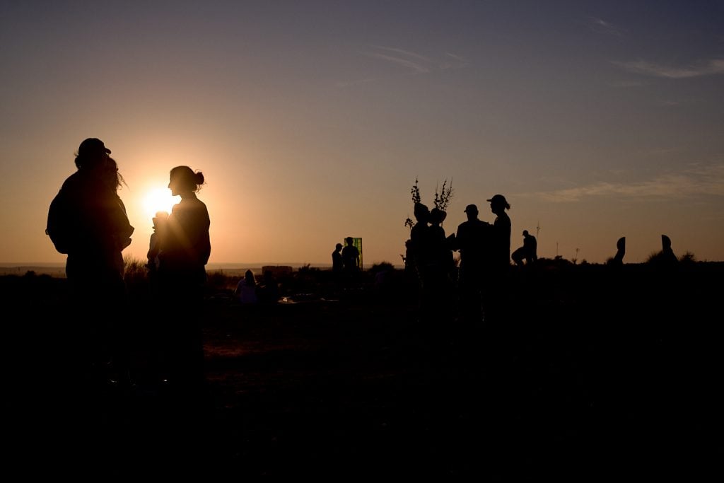 a group of people is backlit by the moon 