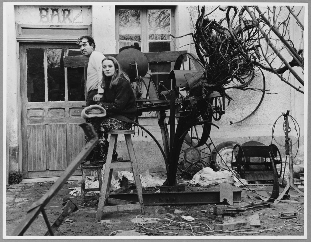 a man and chic woman are in front of a bar surrounded by debris they will use for art 