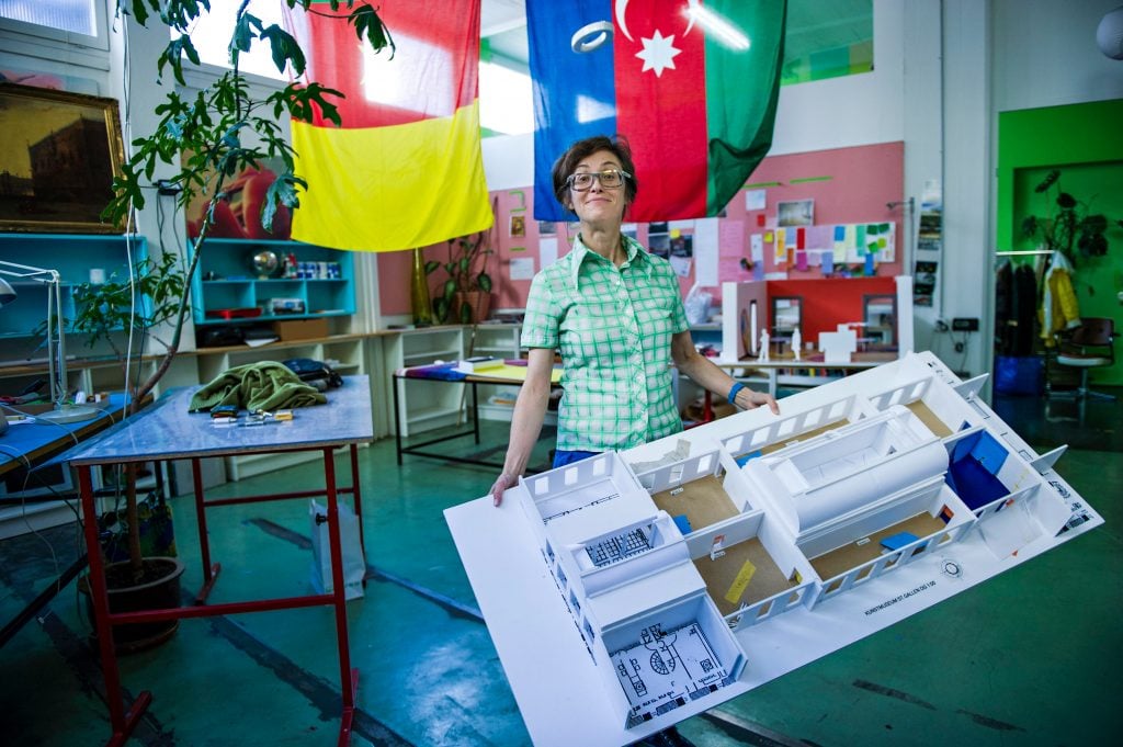 portrait of pipilotti holding a cardboard model of a museum