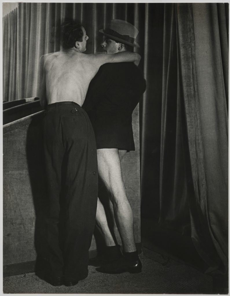 A black and white photograph of two figures—one not wearing a shirt, the other not wearing pants—seen embracing.