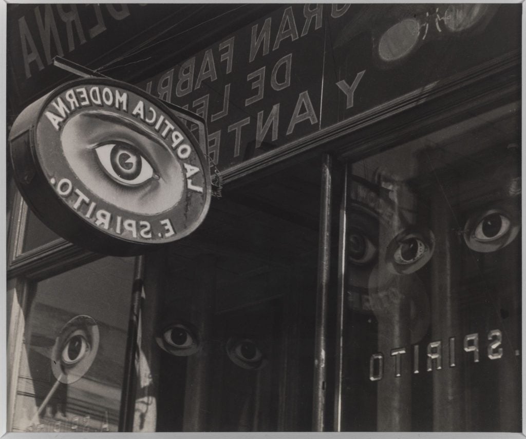 A black and white photograph depicting the outside of a vintage optical shop, replete with lots of eye imagery.